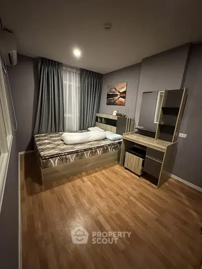 Cozy bedroom with modern furnishings and wooden flooring, perfect for a comfortable living experience.