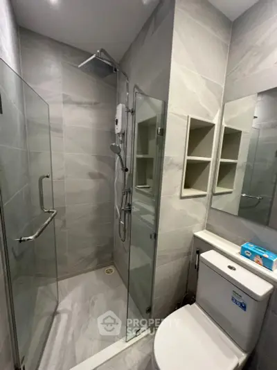 Modern bathroom with glass shower enclosure and sleek fixtures