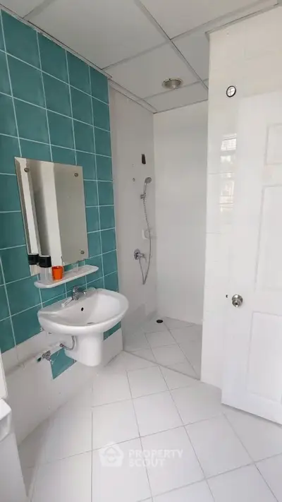 Modern bathroom with teal accent tiles and sleek fixtures