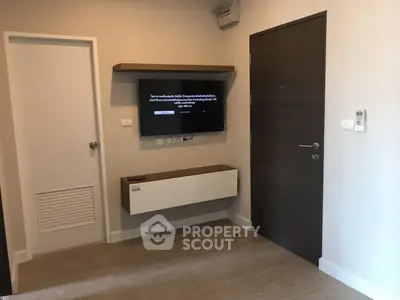 Modern minimalist interior with wall-mounted TV and sleek storage unit in a cozy living space.