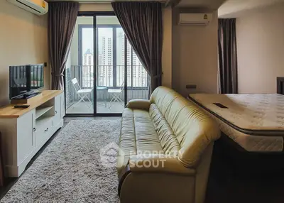 Modern studio apartment with cozy living area and balcony view