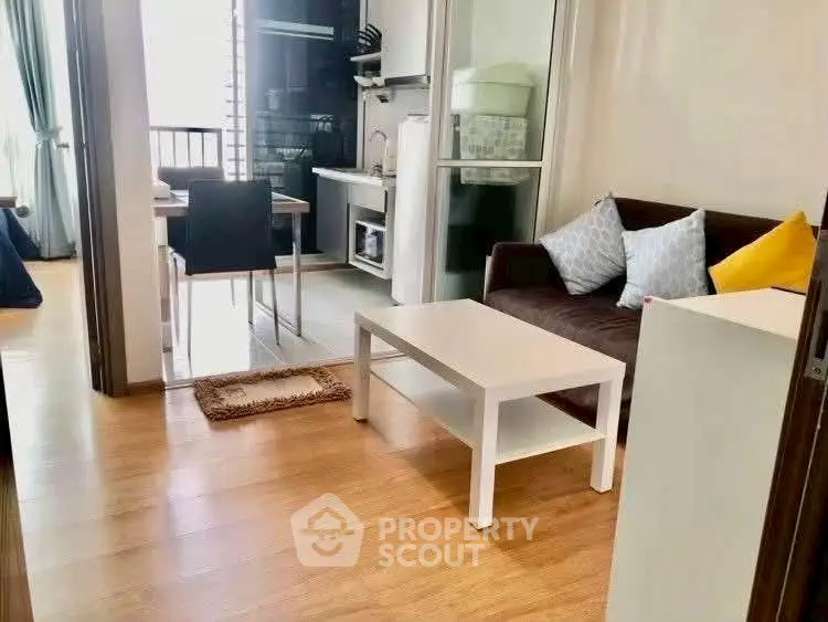 Cozy living room with modern kitchen and dining area, perfect for urban living.