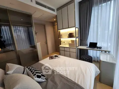 Modern bedroom with stylish decor and natural light, featuring a cozy bed and sleek storage solutions.