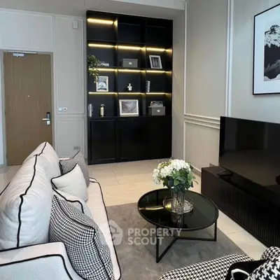 Modern living room with stylish decor and built-in shelving, featuring a sleek TV setup and elegant furnishings.