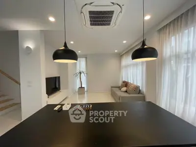 Modern living room with sleek design and stylish lighting fixtures.