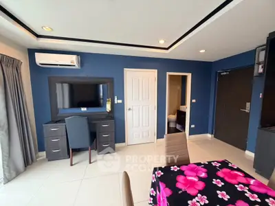 Modern living room with blue walls, air conditioning, and stylish furniture