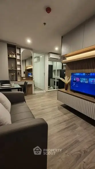 Modern living room with sleek design, featuring a cozy sofa, wall-mounted TV, and stylish decor.