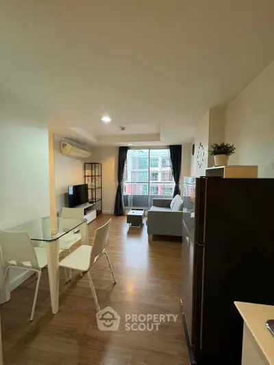 Modern living room with dining area and large window in a stylish apartment.