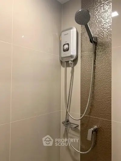 Modern bathroom with sleek showerhead and water heater, featuring elegant tile design.