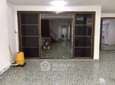 Spacious interior with patterned flooring and sliding glass doors leading to a staircase.