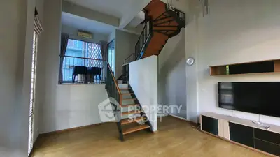 Modern duplex living room with wooden staircase and high ceiling