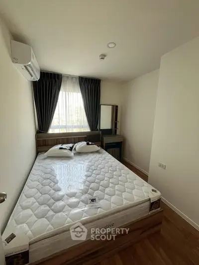 Cozy bedroom with large window and modern furnishings in a stylish apartment.