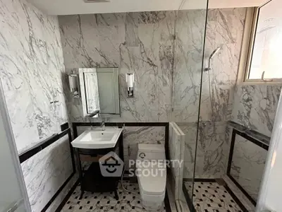 Luxurious marble bathroom with glass shower and elegant fixtures