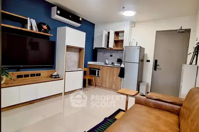 Modern living room with integrated kitchen, featuring sleek furniture and appliances.