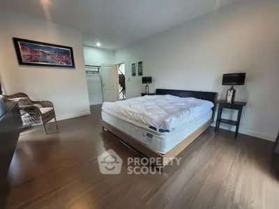Spacious bedroom with modern decor and hardwood flooring