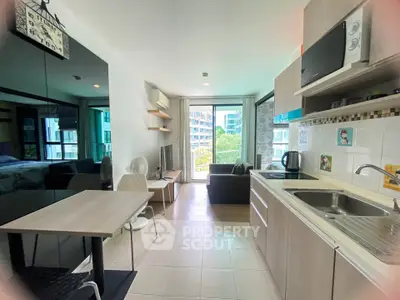 Modern open-layout kitchen and living room with balcony view in stylish apartment.