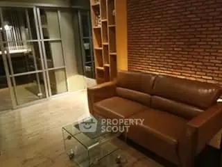 Stylish living room with leather sofa and exposed brick wall for modern urban living.