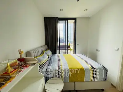Modern bedroom with stylish decor and balcony view in urban apartment