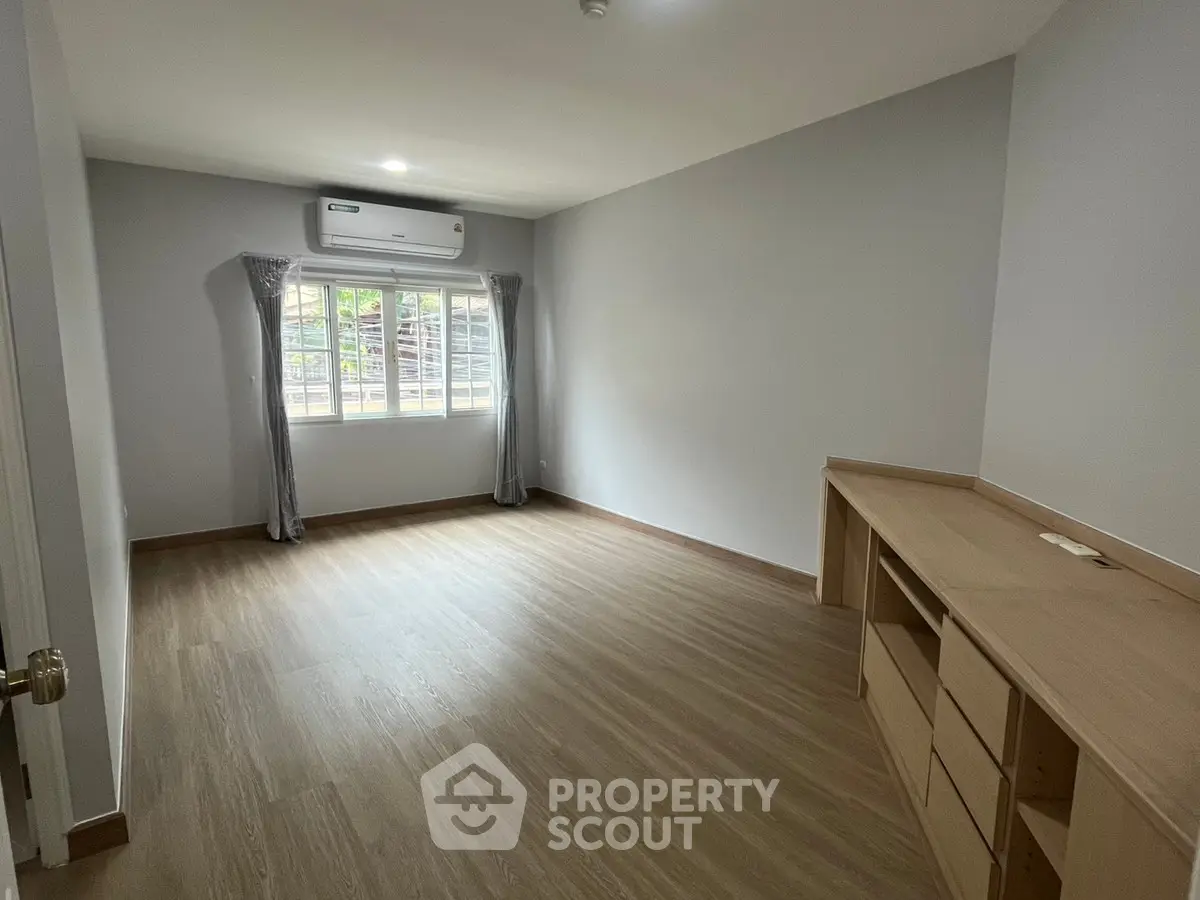 Spacious unfurnished room with wooden flooring and air conditioning, perfect for customization.