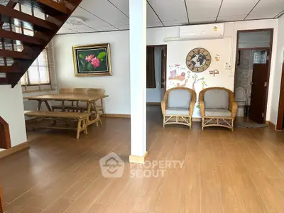 Spacious living area with wooden flooring and cozy seating, perfect for family gatherings.