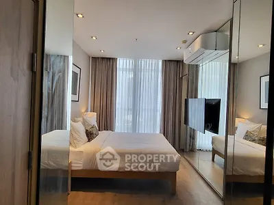 Modern bedroom with mirrored wardrobe and large window, featuring a cozy bed and stylish decor.