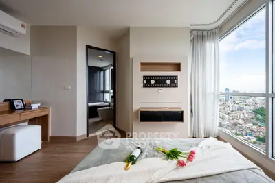 Luxurious bedroom with city view, modern decor, and elegant furnishings.