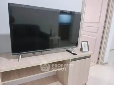 Modern living room with sleek TV on stylish wooden stand, perfect for entertainment.