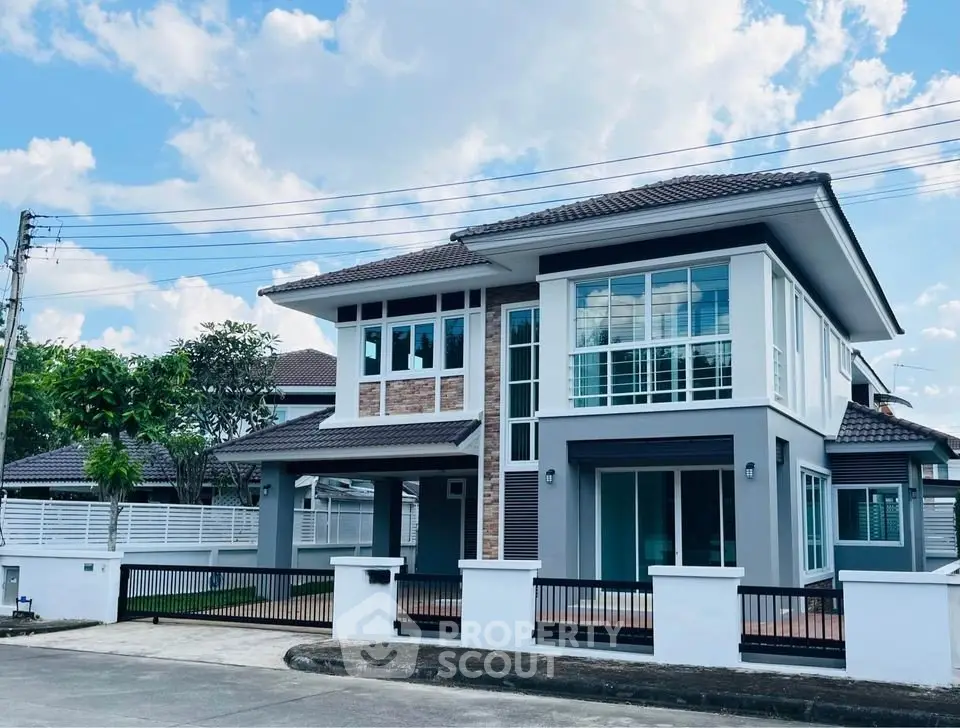 Stunning modern two-story house with large windows and sleek design in a serene neighborhood.