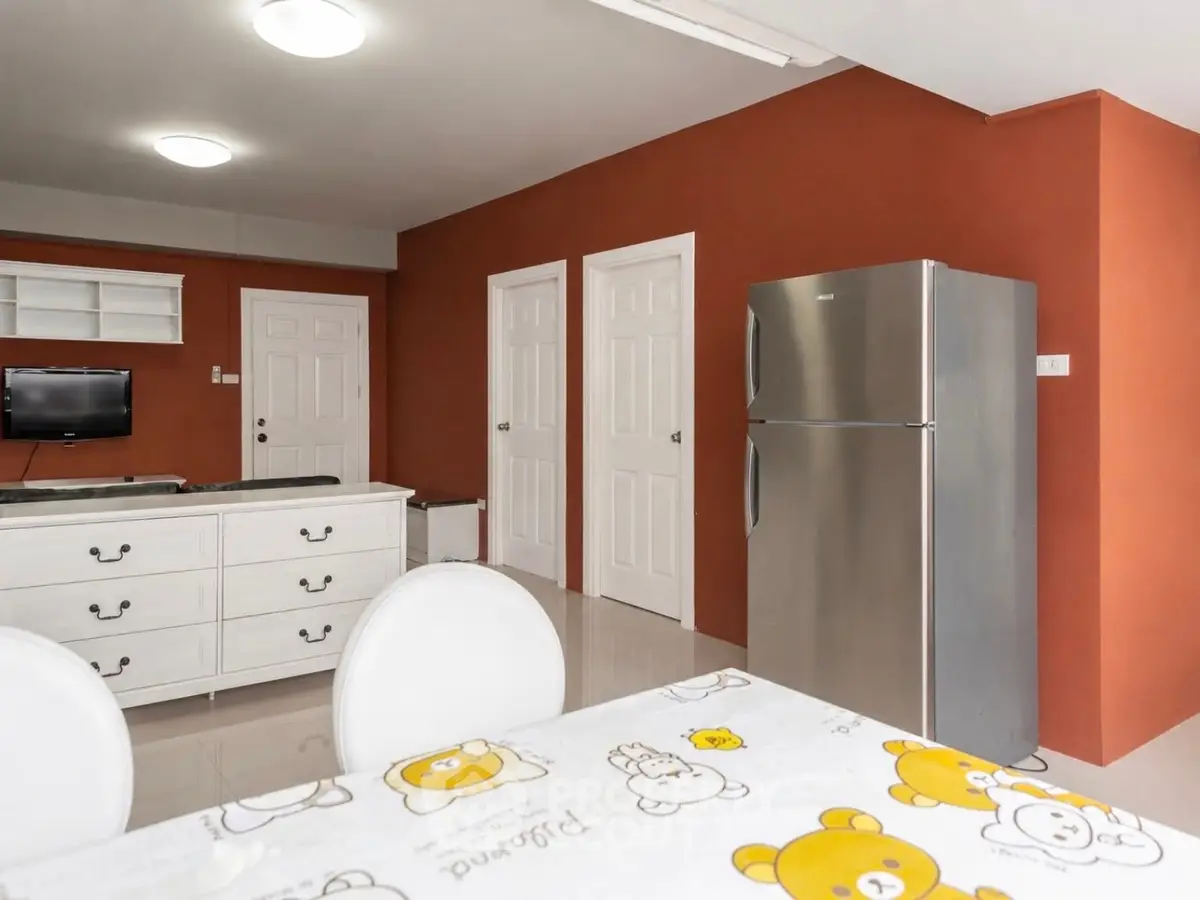 Spacious kitchen with modern fridge and vibrant wall color, perfect for family gatherings.