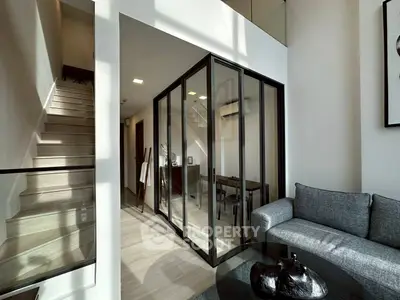 Modern duplex living room with glass-walled study and stylish staircase