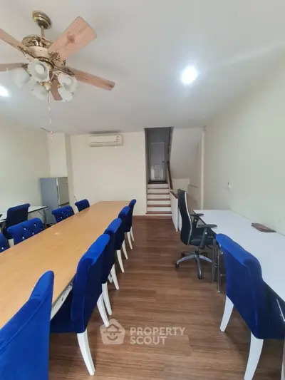 Spacious study room with elegant blue chairs and wooden flooring, perfect for collaborative work.