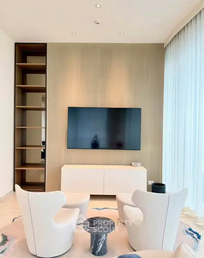 Modern living room with sleek TV setup and elegant white chairs