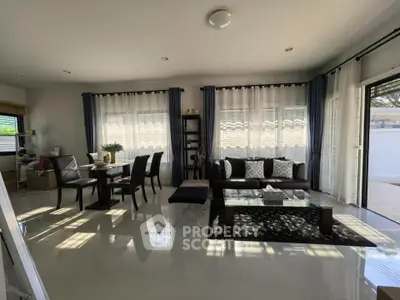 Spacious modern living room with elegant dining area and natural light.