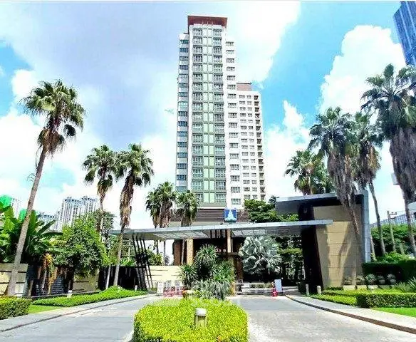 Luxurious high-rise condominium with palm-lined entrance and modern architecture.