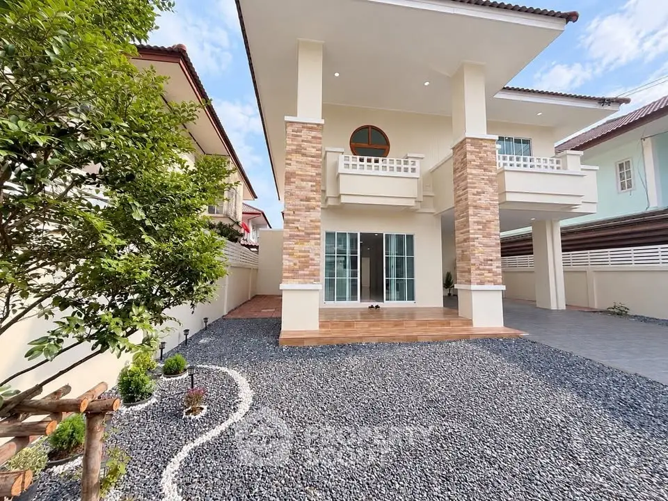 Stunning two-story house with modern facade and spacious gravel driveway.