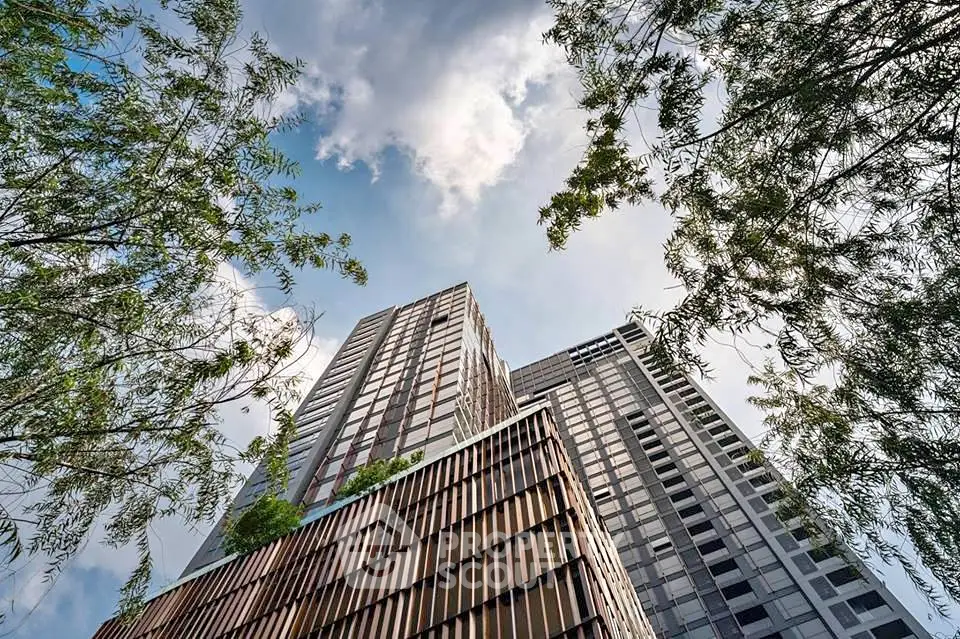 Stunning modern high-rise building with lush greenery and clear blue sky