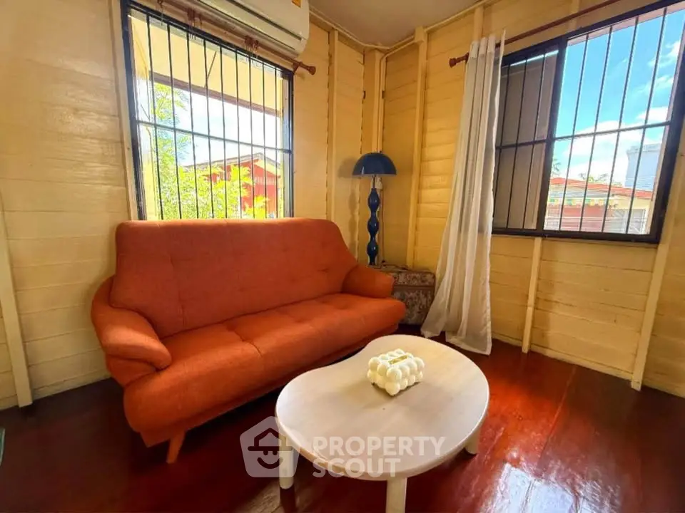 Cozy living room with orange sofa and natural light in charming wooden house