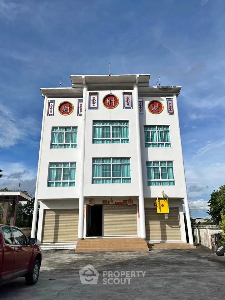 Modern commercial building with unique architectural design and ample parking space.