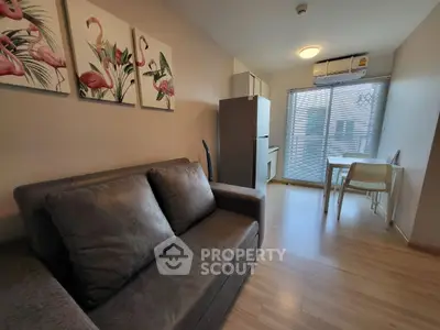 Modern living room with stylish decor and natural light, featuring a cozy sofa and dining area.