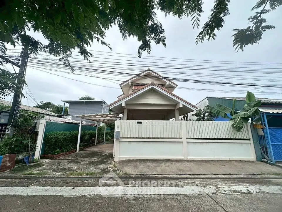 Charming suburban house with gated entrance and lush greenery, perfect for family living.