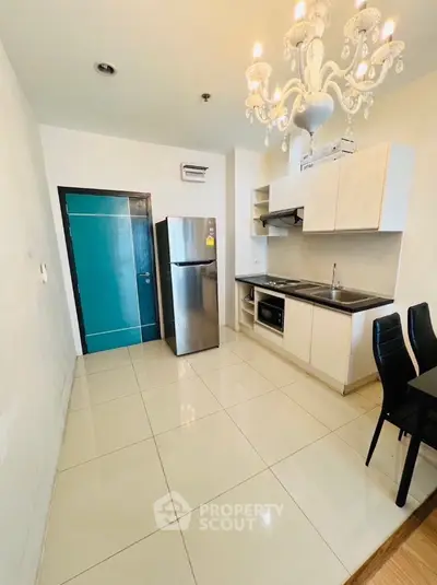 Modern kitchen with stainless steel appliances and elegant chandelier