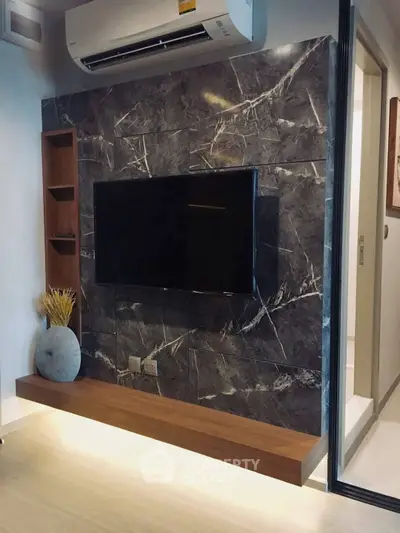 Modern living room with sleek TV wall and air conditioning unit