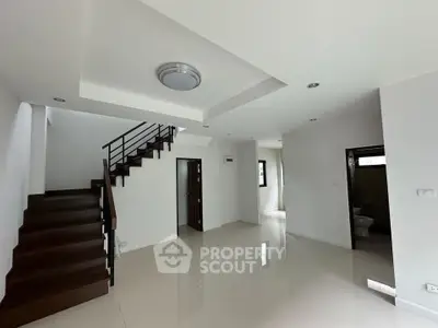 Spacious modern living area with sleek staircase and polished floors