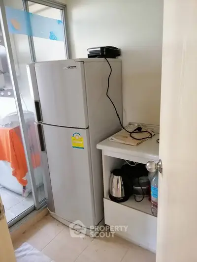 Compact kitchen corner with fridge and appliances in cozy apartment