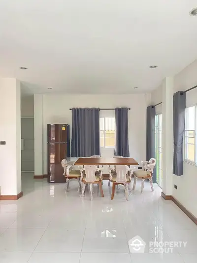 Spacious dining area with elegant furniture and natural light in modern home.