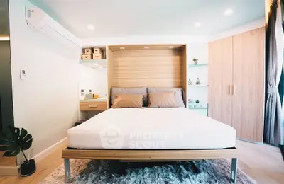 Modern bedroom with stylish decor and ample storage in a cozy apartment.
