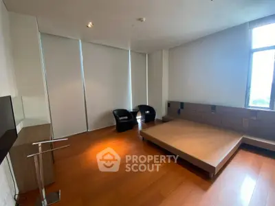 Spacious bedroom with modern minimalist design and large windows for natural light.