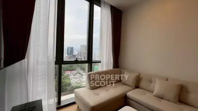 Modern living room with large windows offering stunning city views and cozy seating area.