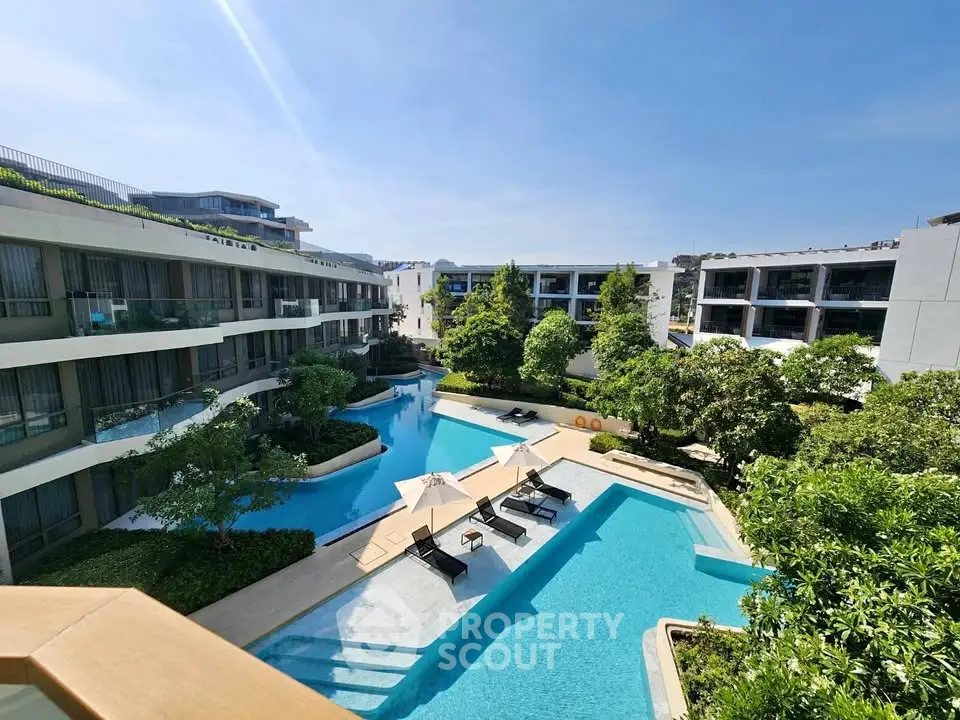 Luxurious apartment complex with stunning pool and lush greenery