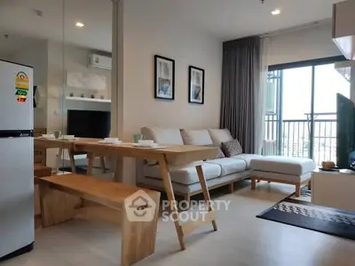 Modern living room with stylish furniture and balcony view in a cozy apartment.